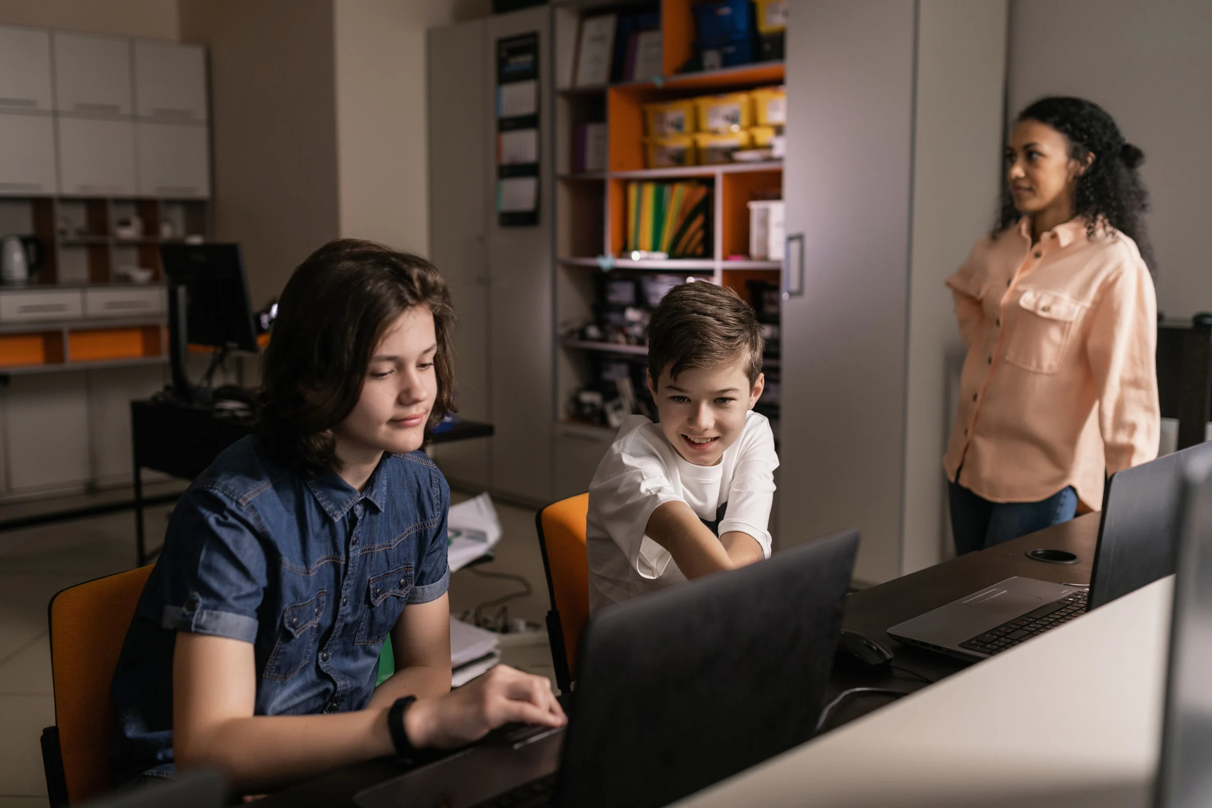 Claude for Teachers Ra Mắt: Anthropic Đưa Claude Code Và Cowork Vào Công Việc Của Giáo Viên 1 Giáo viên hướng dẫn học sinh sử dụng máy tính trong lớp học, minh họa hệ sinh thái giáo dục số.