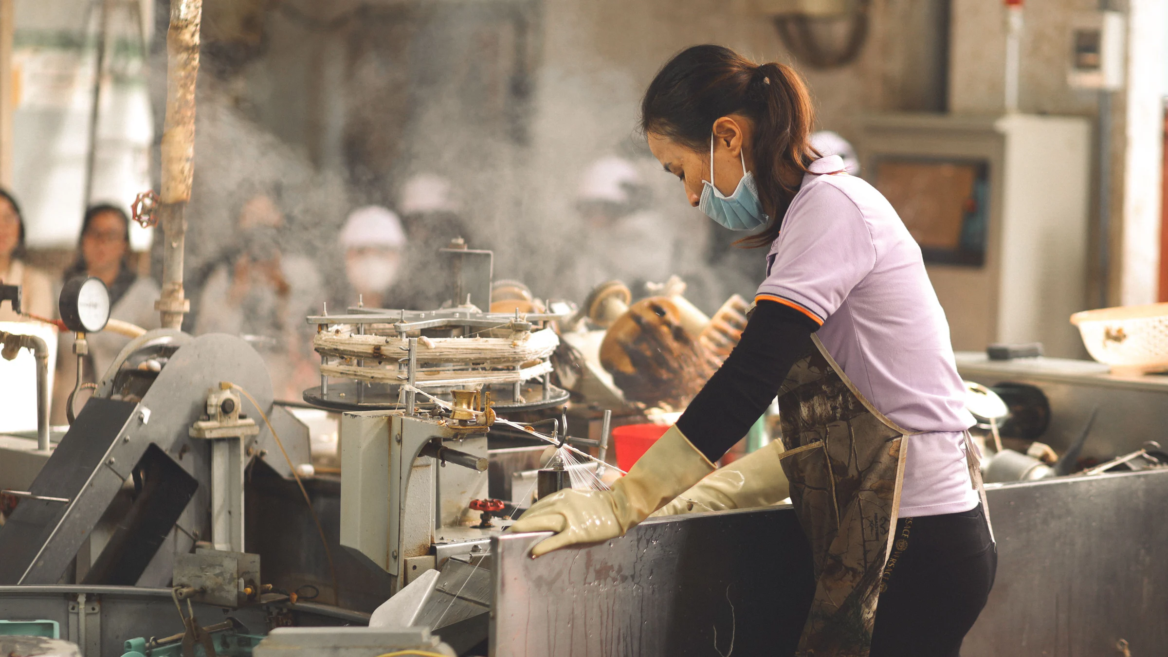Nữ công nhân vận hành máy trong xưởng sản xuất, minh họa thu nhập từ sức lao động trực tiếp