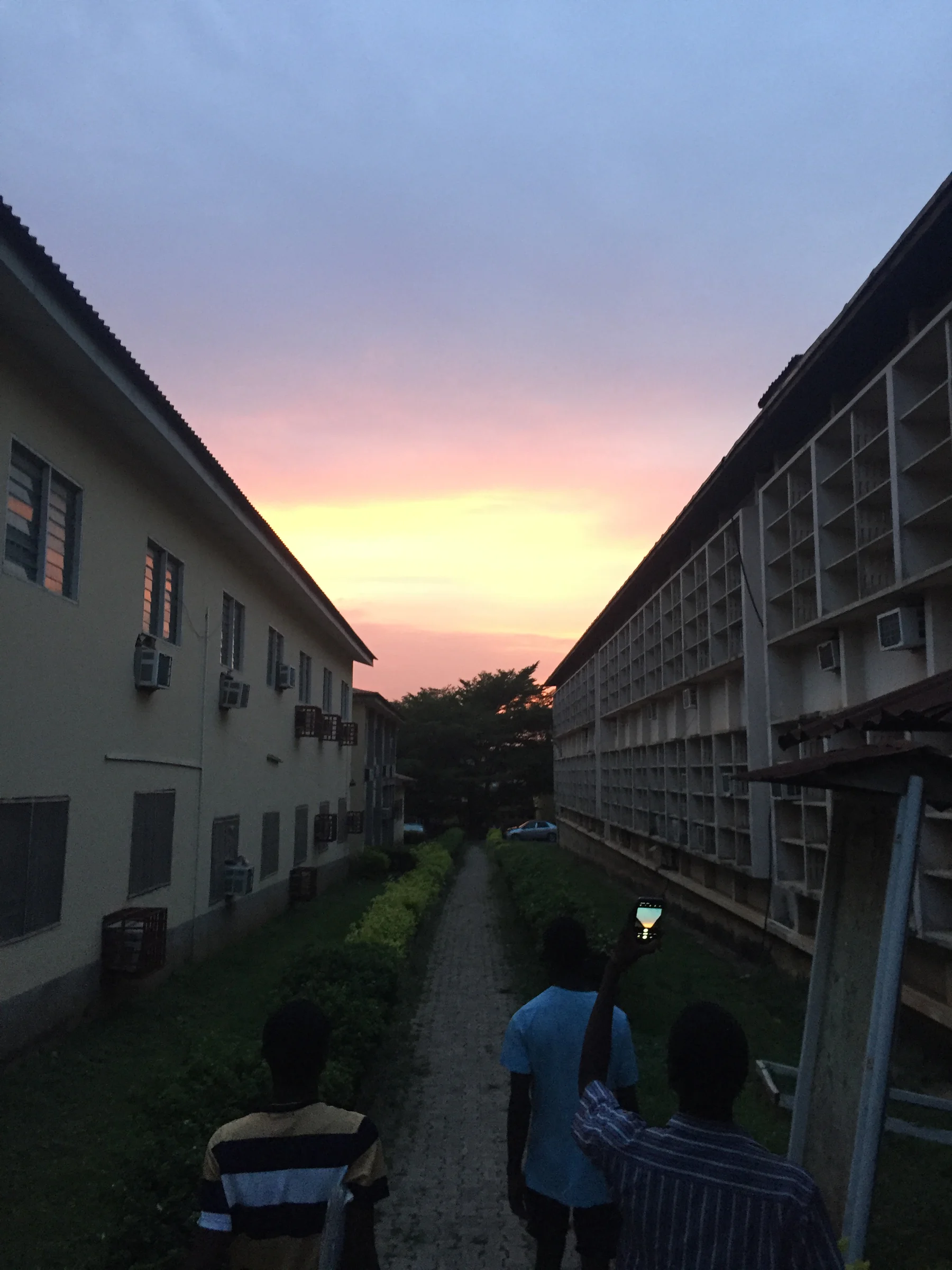 Cảnh đô thị lúc hoàng hôn với bầu trời ấm và silhouette tối, dùng tham chiếu mood ánh sáng chiều tà.