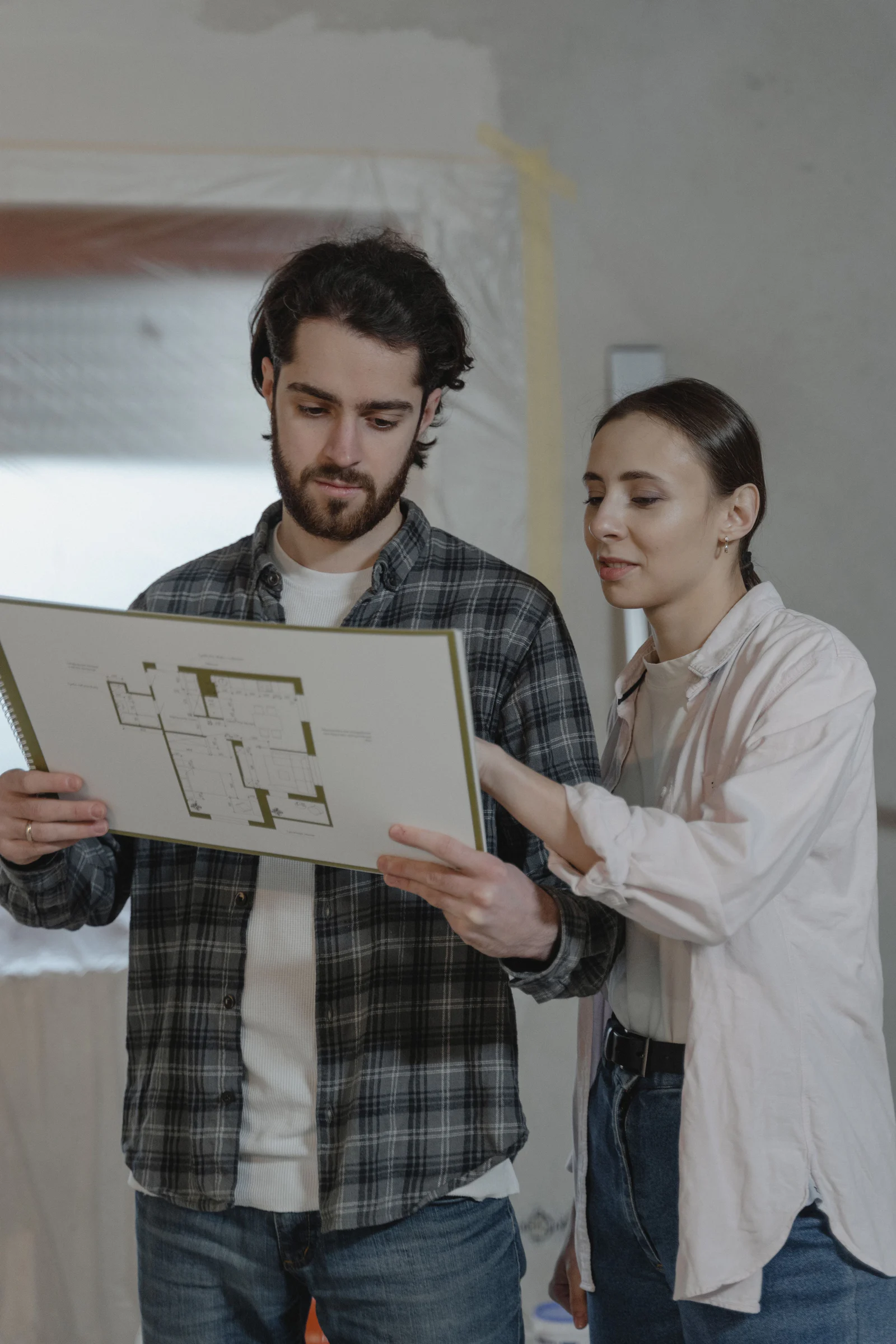 Hai người xem bản thiết kế trong một dự án sửa nhà, minh họa ChatGPT Work hỗ trợ so sánh báo giá và tiến độ.