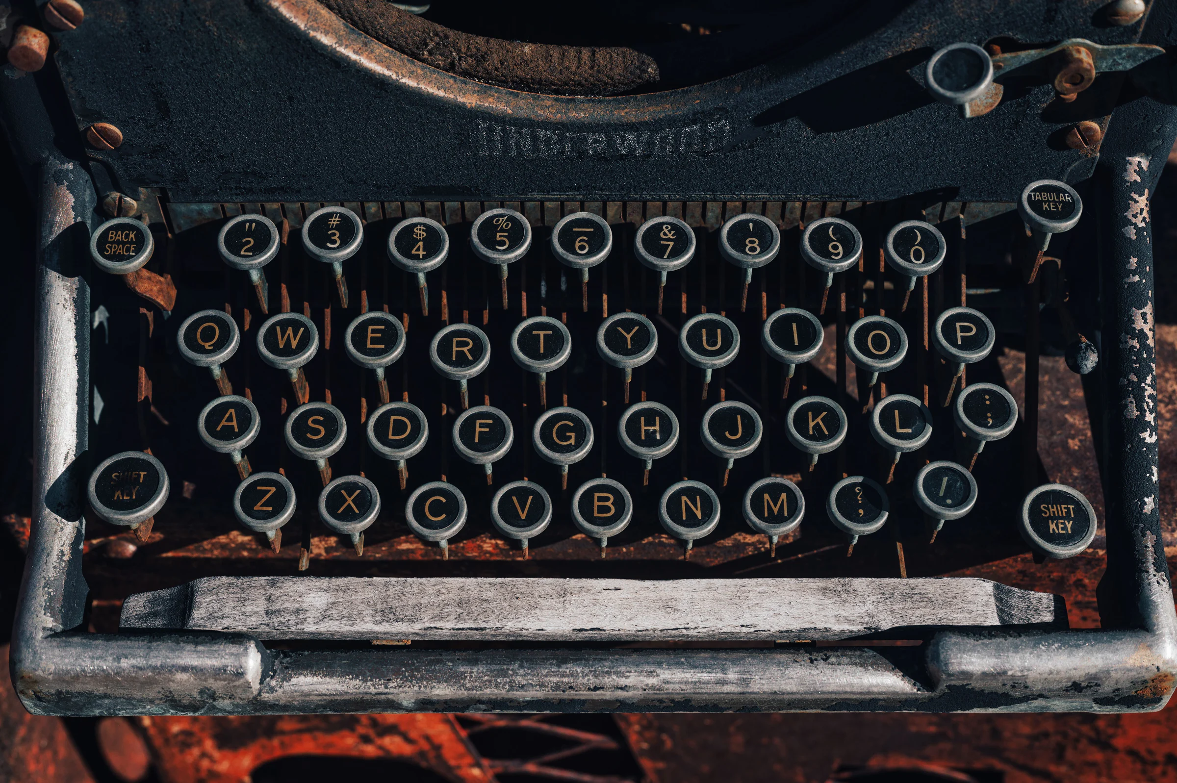 Bàn phím máy đánh chữ cổ với các phím chữ, minh họa lịch sử typography và sự khác biệt giữa kiểu chữ in với webfont.