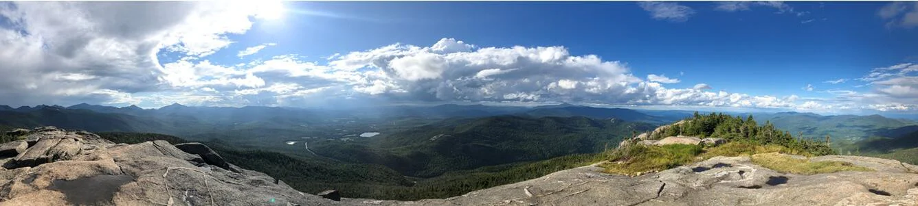 Thung lũng Adirondack với tiền cảnh cây xanh và các dãy núi xa