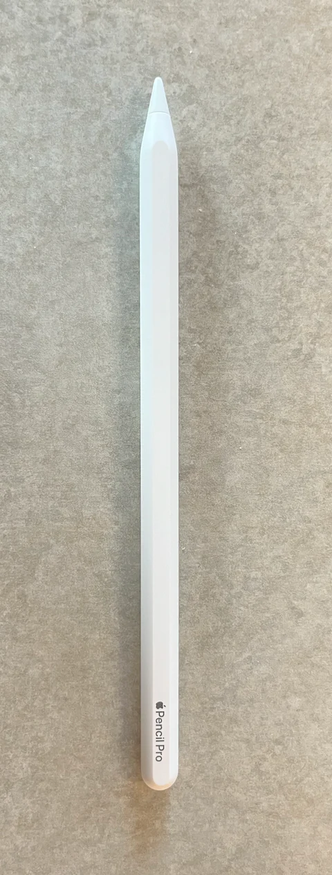 Apple Pencil Pro màu trắng được chụp toàn thân trên nền đá xám
