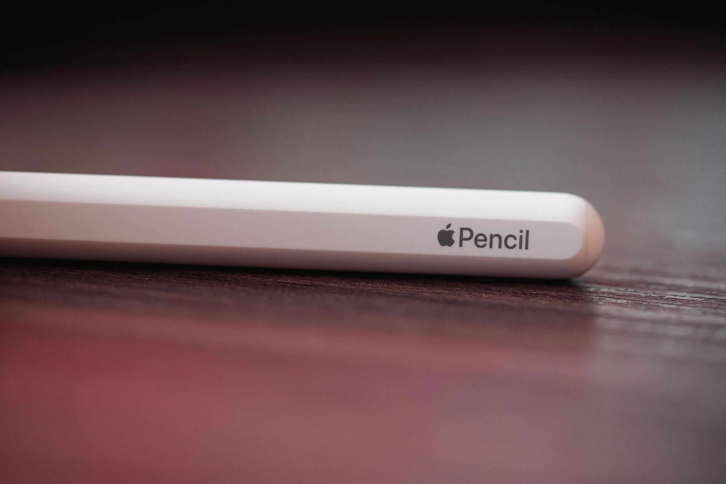 Ảnh macro đầu và thân Apple Pencil trên bề mặt tối