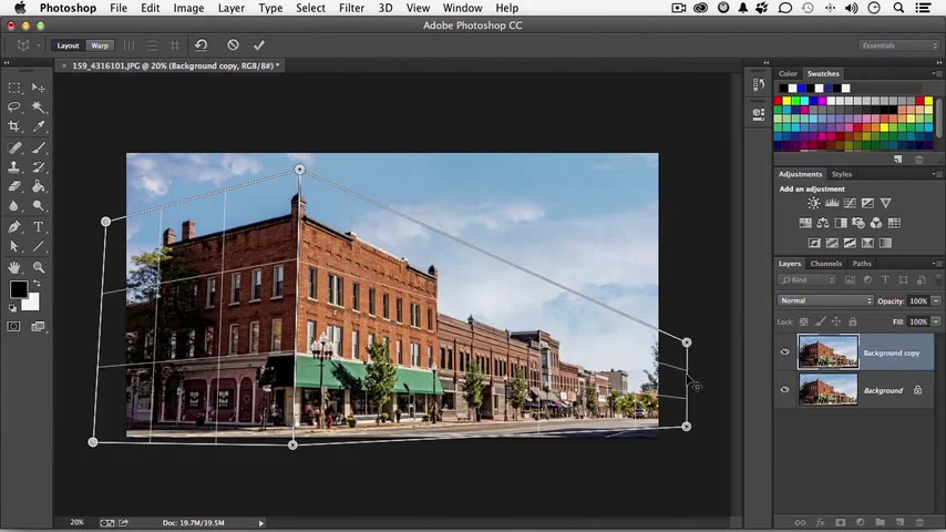 Lưới Perspective Warp bao phủ toàn bộ mặt tiền và mặt bên của công trình trong Photoshop.